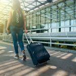 Devojka sa rancem vuče kofer