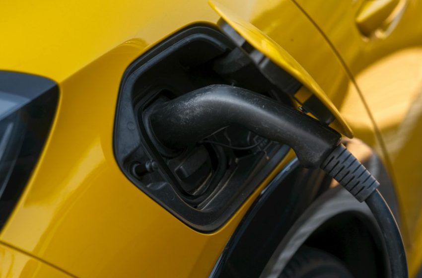 Žuti električni automobil se puni na punjaču
