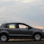 Sivi automobil hečbek parkiran pored puta pri zalasku sunca