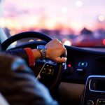 Unutrašnjost automobila sa vozačem koji se drži za volan