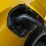 Žuti električni automobil se puni na punjaču