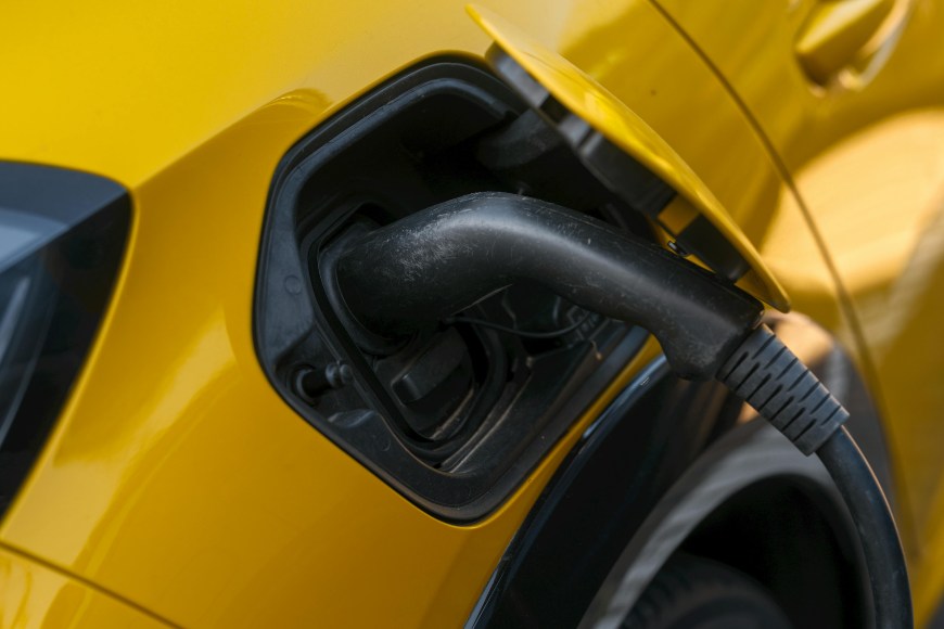 Žuti električni automobil se puni na punjaču